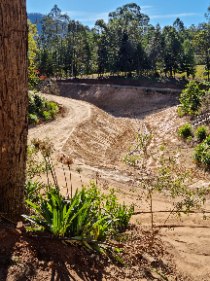 A large rural block excavated and graded flat, surrounded by trees